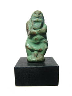 Romano-Egyptian faience figure of a comedic actor: A Romano-Egyptian faience figure of a comedic actor, c. 1st - 2nd Century AD, in the form of a dwarf wearing a heavy robe and mask, the tip of his phallus peaking from beneath the hem of his robe. 3