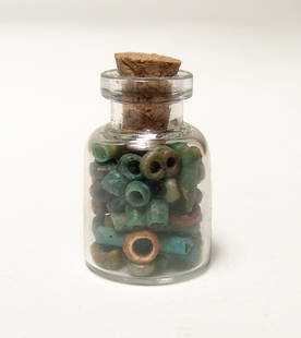 A small bottle filled with Egyptian faience beads: A small bottle filled with Egyptian faience beads, Late Period, c. 664 - 332 BC, multi-colored disc and tubular beads of high quality. Bottle measures about 1 in (2.5 cm) in height with cork. Beads: