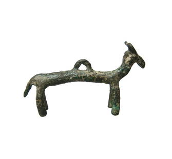 A Near Eastern bronze figure in the form of a bull: A Near Eastern bronze figure in the form of a bull, c. 1200 - 800 BC, with long narrow body, legs and tail. The head with narrow muzzle and curled horn, a suspension loop is at center of the back. L: