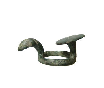 A Near Eastern bronze harness ring: A Near Eastern bronze harness ring, later 1st Millennium BC, the ring with a raised oval disk with incised radiate lines opposite the stylized head of an animal. L: 2 in (5 cm). Nicely patinated. Cf.