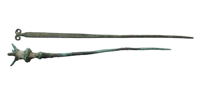 A pair of nice Near Eastern bronze pins: A pair of nice Near Eastern bronze pins, c. 1200 - 600 BC, the first with a widely ridged terminal surmounted by 4 prongs, L: 5 1/4 in (15.8 cm), and the second with flattened profile along the upper