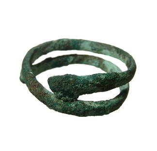 A Near Eastern bronze hair ring: A Near Eastern bronze hair ring, c. 1000 - 600 BC, fashioned from a narrow continuous strip of bronze with tapered ends. Dia: 1 3/4 in (4.4 cm). Ex West Virginia private collection.