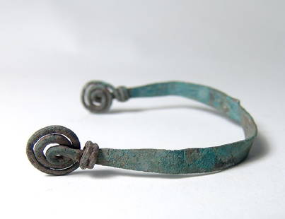 A Villanovan bronze bracelet: A Villanovan bronze bracelet, c. 8th - 7th Century BC, fashioned from a single strip of bronze, the ends pulled to wire and coiled into spirals. Well-preserved and attractively patinated. Ex Barstow,