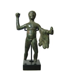 An Etruscan bronze figure of Herakles: An Etruscan bronze figure of Herakles, 3rd - 2nd Century BC, depicted nude, with right hand raised overhead, likely originally holding a club, the skin of the Nemean lion draped over left forearm.