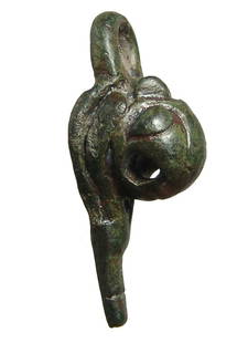 A Roman bronze attachment with lion: A Roman bronze attachment with lion's head, c. 1st - 3rd Century AD, the piece pendant-shaped with pointed bottom and loop at top. L: 1 7/8 in (4.7 cm). Perhaps the leg of a box or similar. Nicely