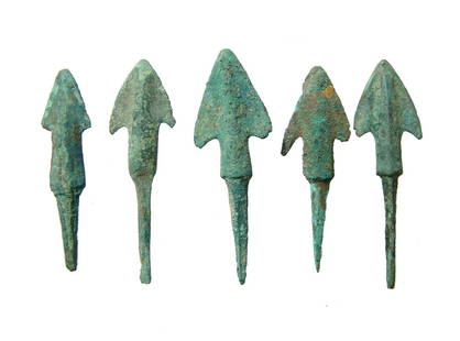 A lot of 5 Near Eastern bronze arrowheads: A lot of 5 Near Eastern bronze arrowheads, c. 1000 - 600 BC, each with triangular blade with pronounced midribs, the substantial stems with long tang for mounting into a shaft. Largest 2 in (5 cm).