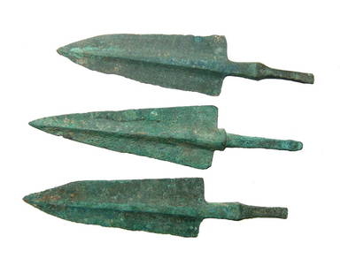 A lot of 3 Near Eastern bronze arrow points: A lot of 3 Near Eastern bronze arrow points, c. 1000 - 800 BC, each with pronounced midrib, tapered blade and squared shoulders. Each with slender stems for mounting into the shaft. Largest 4 1/8 in