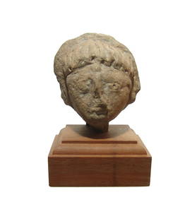 A Phoenician ceramic head of a man: A Phoenician ceramic head of a man, c. 7th - 6th Century BC, with Egyptianizing features - almond-shaped eyes, angular nose, narrow mouth and short wig-like hair. The back of the head is framed by a
