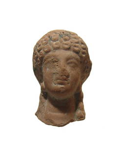 An attractive Greek terracotta head of a woman: An attractive Greek terracotta head of a woman, c. 5th Century BC, with Archaic style, her hair in tight curls framing her face and pulled back into a plait at the nape of her neck. H: 2 1/8 in (5.3