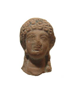 An attractive Greek terracotta head of a woman: An attractive Greek terracotta head of a woman, c. 5th Century BC, with Archaic style, her hair in tight curls framing her face and pulled back into a plait at the nape of her neck. H: 2 1/8 in (5.3 c