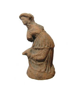 A Hellenistic terracotta figure of a woman: A Hellenistic terracotta figure of a woman, 3rd - 2nd Century BC, reaching down and adjusting the strap of her sandal. She wears a chiton and himation, her head diademed with hair pulled back into a