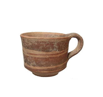 A nice Cypriot handled cup: A nice Cypriot handled cup, c. 800 - 600 BC, with near vertical walls, tapered disk base and loop handle. The vessel is adorned with wide and narrow bands in dark brown slip. 2 3/4 x 4 in (7 x 10.2