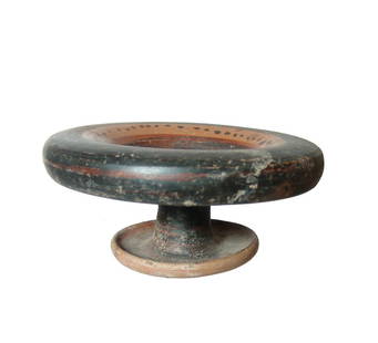 An attractive Greek pedestal dish: An attractive Greek pedestal dish, 4th - 3rd Century BC, the pedestal base with widely flared foot, the interior of the dish decorated with bands of black glaze, the bare clay with rows of black