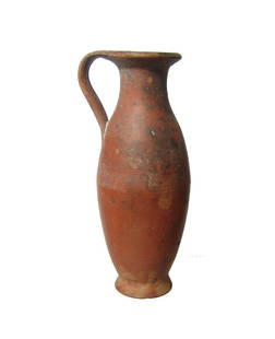 A Hellenistic ceramic olpe: A Hellenistic ceramic olpe, c. 3rd - 1st Century BC, of tall, narrow form, the orange slip with black mottling in areas. H: 5 1/4 in (13.3 cm). Light deposits. Ex collection of Sir William Whitfield,
