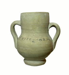 A Roman handled cup from Cartagena, Spain: A Roman handled cup from Cartagena, Spain, c. 1st - 2nd Century AD, fashioned in a creme ware. Well-preserved with antique collector's notation Cartagena, SAp 1960 on one side in heavy pencil. H: 4