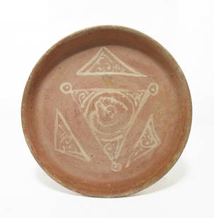 A Byzantine terracotta bowl: A Byzantine terracotta bowl, c. 12th Century AD, the interior decorated with creme painted triangle and scroll motif. D: 7 1/2 in (19.1cm), H: 2 in (4.9cm). Ex Montreal, Canada private collection