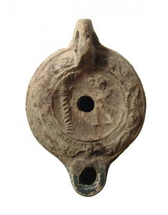 Roman discus lamp depicting Cupid: A Roman discus lamp depicting Cupid within the concave disk, late 2nd - early 3rd Century AD, the shoulder is decorated with a raised floral design, there is a loop handle, low ring base on foot with