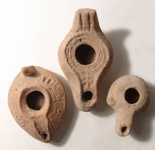 A lot of 3 ancient ceramic lamps from the Holy Land: A lot of 3 ancient ceramic lamps from the Holy Land. The first is a Hellenistic type, c. 3rd - 2nd Century BC, with long spout and pierced lug to one side, L: 2 3/4 in (7 cm); the second is a Byzantin