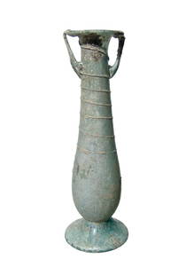 A slender Roman pale blue glass cosmetic bottle: A slender Roman pale blue glass cosmetic bottle, c. 4th Century AD, with widely flared base, the body decorated with trailing in the same color glass as the body, two small handles attach from the