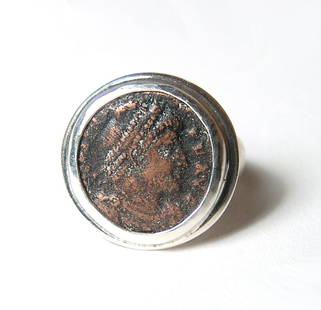 A silver ring set with a Roman bronze coin: A silver ring set with a Roman bronze coin. The coin was struck under the Roman emperor Valens, AD 367 - 378, and features his portrait on one side and the emperor standing with a captive on the