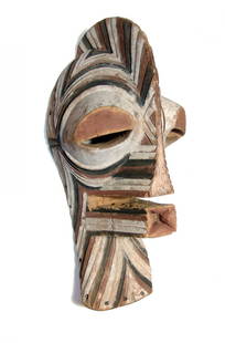 A large Songe Kifwebe mask: A large Songe Kifwebe mask, Democratic Republic of Congo, mid-20th Century, with exaggerated features - pursed lips, large eyes and nose extending to a crest that runs atop the head. The surfaces are