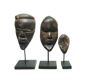 A group of three miniature Dan masks: A group of three miniature Dan masks, Western Africa, mid-20th Century, each nicely carved with short or no hair, narrow eyes and jutting chin. Sometimes referred to as 'Passport Marks' and worn or