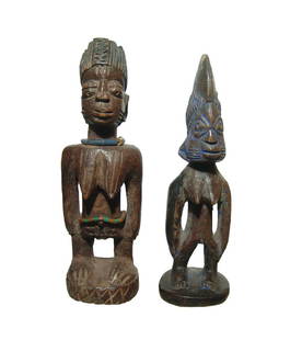 A pair of Yoruba offering figures: A pair of Yoruba offering figures, Nigeria, mid-20th Century AD, each depicted in traditional form standing on integral bases and wearing elaborate headdresses. One wears a beaded band around his