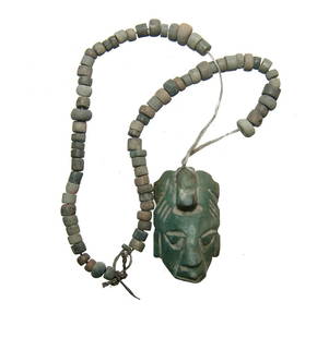 A greenstone Mexican-style replica maskette pendant: A greenstone Mexican-style replica maskette pendant strung on beaded necklace, nicely carved with an avian headdress, the beads carved in various stones. Maskette 1 3/8 in (3.4 cm) in length.