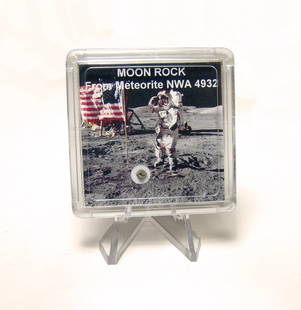 A fragment of moon rock in a display case: A fragment of moon rock in a display case. The fragment is of the Lunar gabbro meteorite NWA4932. The moon is regularly struck by meteorites which eject lunar rocks into space. With the right