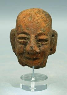 A choice ceramic Olmecoid head: A choice Olmecoid head, Guatemala, c. 200 BC - AD 200. This fine orange-ware example depicts a smiling individual with elongated, pierced ears. H: 2 3/4 in (6.9 cm). Strong mineral deposits. Mounted