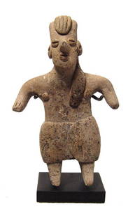 A cute Colima standing woman in a skirt: A cute Colima standing woman in a skirt, West Mexico, 100 BC - AD 250, with bifurcated feet, her face nice detailed with long hair braid falling to front. H: 3 1/4 in (8.3 cm). Well-preserved with