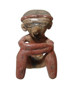 A Chinesco Type C seated male figure: A Chinesco Type C seated male figure, West Mexico, c. 100 BC - AD 250, with arms crossed over his knees. He wears a low domed head piece and with black painted details which include his tattooed