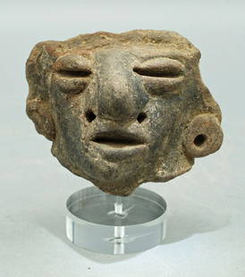 An excellent Classic Maya head: An excellent Classic Maya head from Guatemala, c. AD 250 - 600, depicting an individual adorned with large ear spools and facial piercings. H: 2 3/4 in (6.9 cm). Strong mineral deposits mounted on