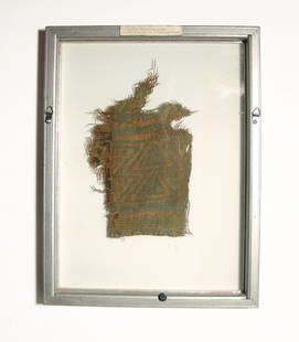 A lovely green and yellow textile poncho fragment: A lovely poncho fragment, Tiahuanaco, Bolivia, AD 600 - 1000, with a trophy head pattern in deep green and golden yellow dyed thread. Mounted in a custom metal and glass frame. Textile itself measures