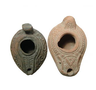 A pair of attractive Byzantine lamps, Egypt: A pair of attractive Byzantine lamps, Egypt, c. 6th - 7th Century AD, the first oval with angled shoulders adorned with a nice floral device in high relief, L: 3 1/4 in (8.3 cm). The second features