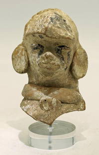 A fine Vera Cruz bust of an individual with headdress: A fine Vera Cruz bust, Mexico, c. AD 400 - 700, depicting an individual wearing an incised headdress, huge ear ornaments and a broad necklace, his face retains its chapopote decor, as well as much of