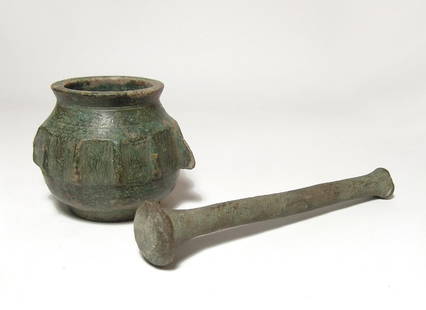 A Spanish-Moorish bronze mortar with pestle: A Spanish-Moorish bronze mortar with pestle, c. 14th - 16th Century, the body rounded with a row of vertically raised prunts, raised disk base and two narrow incised lines around the base of the