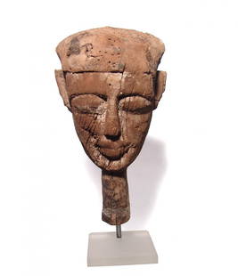 An Egyptian wood mummy mask, Late Period: An Egyptian wood mummy mask, Late Period, c. 664 - 332 BC, the facial portion from an anthropoid sarcophagus lid, the features attractive with deep set eyes and large lips and false beard; all cut