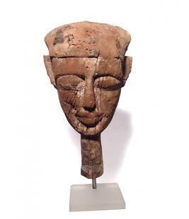 An Egyptian wood mummy mask, Late Period: An Egyptian wood mummy mask, Late Period, c. 664 - 332 BC, the facial portion from an anthropoid sarcophagus lid, the features attractive with deep set eyes and large lips and false beard; all cut fro