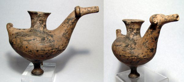 Western Iran, c.1200 - 1000 BC, stylized ram: A grey-ware vessel in the form of a stylized ram, Western Iran, c.1200 - 1000 BC, with curled horns, ovoid body and a very narrow base. The snout of the ram is a spout and the vessel was used to pour
