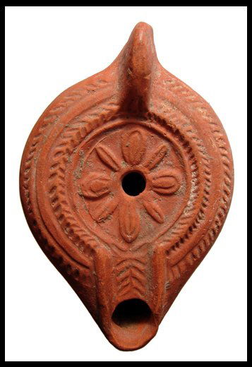 Roman North Africa, redware oil lamp with rosette: An attractive red ware oil lamp, Roman North Africa, 4th - 5th Century AD. Red-ware terracotta lamp, mould made, with flat disc adorned with a rosette. Shoulder decorated with angled ridges. Base cons