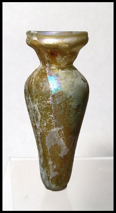E. Mediterranean glass funnel mouth jar: A pale yellow free blown funnel mouth jar, Eastern Mediterranean, 3rd - 4th Century AD, with small concave base, pinch neck and rim folded in. H: 4 ½" (11.4 cm). Intact with attractive iridescence. E