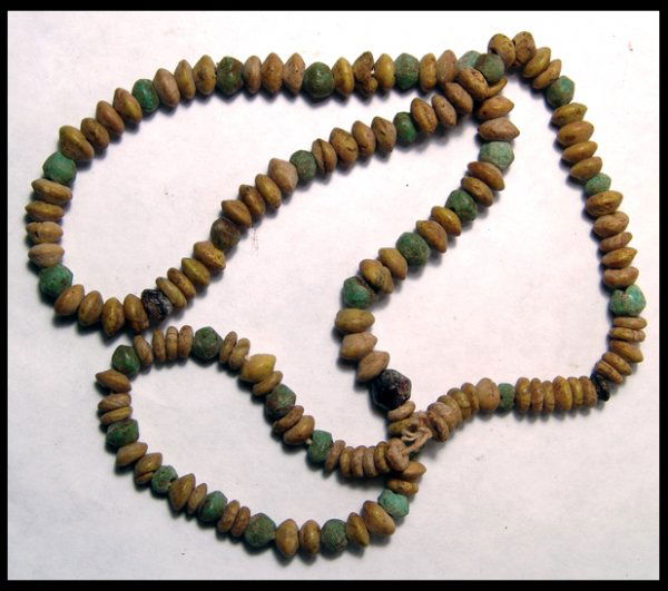Hellenistic Greece, string of glass beads: A nice string of Hellenistic glass beads, c.3rd - 2nd Century BC. The beads are in opaque yellow and green glass and are round with tapered edges. A few root beer colored beads are included. Strand me