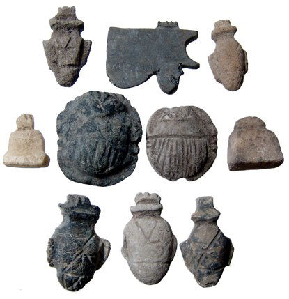 Lot of 10 stone amulets from upper Egypt: A lot of 10 stone amulets from upper Egypt, Late Period, c.664 - 30 BC, which include a pair of scarabs, four 'ib' or heart amulets, two platform amulets and an obsidian wedjat or Eye of Horus. Length