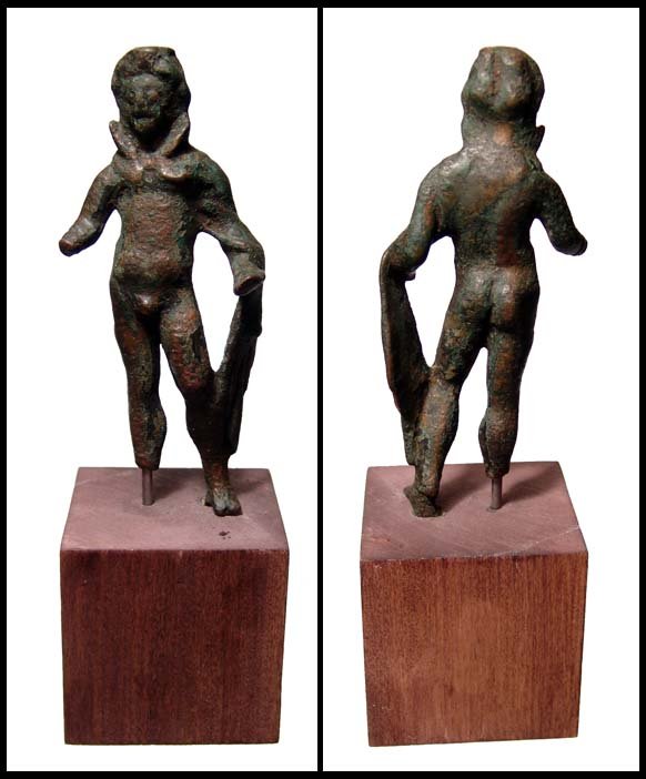 Scarce Roman bronze figure of the god Men: Bronze figure of the god Men, Roman, 2nd - 3rd Century AD. He stands nude, wearing tight fitting cap, cloak over shoulder and crescent at neck. Loss of right hand and foot. H: 4 ¼" (10.7 cm). Mounted
