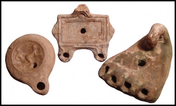 Lot of 3 Roman terracotta oil lamps: A lot of 3 terracotta oil lamps. The first is Roman, c.3rd - 4th Century AD, mouldmade, in the form of a flat box, with two nozzles and three handles, two on the side and the central one impressed wit