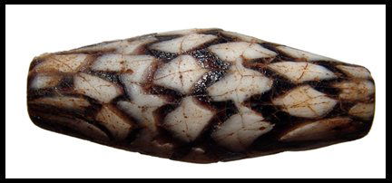 Beautiful Islamic glass bead, zigzag design: A beautiful Islamic glass bead, Eastern Mediterranean, c. 7th - 8th Century AD, with a zigzag design in deep purple and white. Some age cracks, but a lovely bead. L: 1 ½" (3.6 cm).