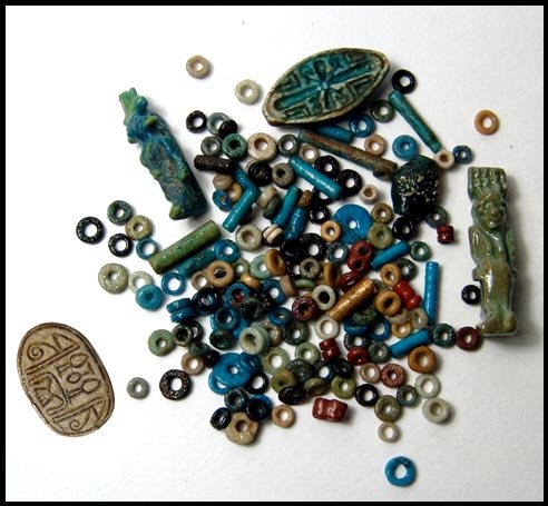 A nice mixed lot of small Egyptian items: A nice mixed lot of small Egyptian items including a green glazed steatite cowroid, 21 x 11mm, a light green amulet of Bes wearing feathered headdress, 2.7 cm and a Ptolemaic blue and green faience am
