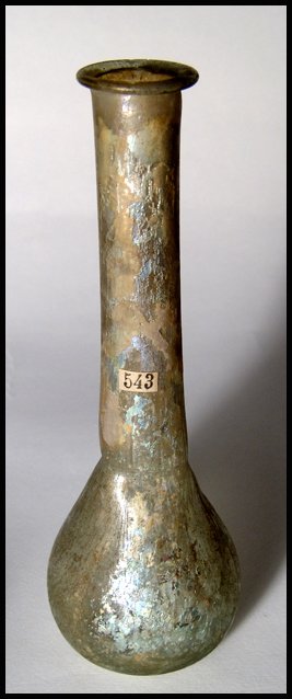 A light blue-green Roman glass bottle: A light blue-green Roman glass bottle, c.2nd Century AD, with folded rim and tong marks at the base of the neck. Pontil mark on base. Old collection labels on neck and on the base with the find spot -