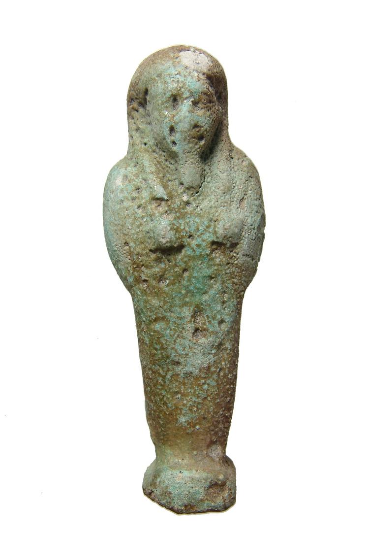 Egyptian light green faience ushabti, Late Period: An Egyptian light green faience ushabti, Late Period, c. 664 - 332 BC, depicted mummiform wearing tripartite headdress with false beard, arms folded at chest. L: 3 1/4 in (8.2 cm). Light green color w